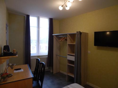 a room with a desk and a tv in a room at Le Lion D'or in Ouroux en Morvan