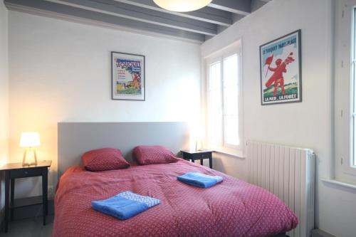 a bedroom with a bed with two blue towels on it at Entre Mer et Golf in Étretat