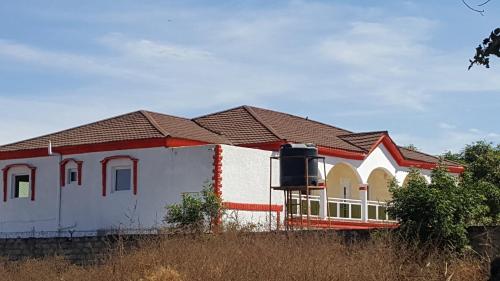 a house with a red and white at Ous and Buwa in Yundum