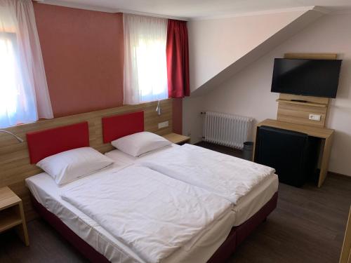 a bedroom with a bed and a flat screen tv at Hotel Well Garni in Wittlich