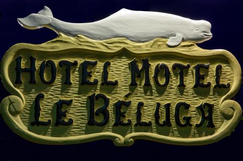 a sign with a hog jumping on top of a horse house sign at Hôtel Motel Le Beluga in Tadoussac
