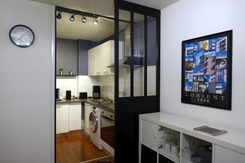 une cuisine avec des armoires blanches et une laveuse et une sécheuse dans l'établissement Ty Nevet - Appartement avec balcon et parking privé, à Quimper