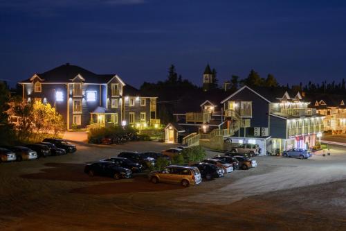 a group of houses with cars parked in a parking lot at Hôtel Motel Le Beluga in Tadoussac