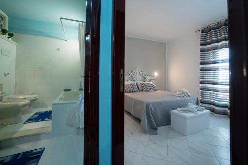 a bedroom with a bed and a bathroom with a tub at Home Barbera in Castellammare del Golfo