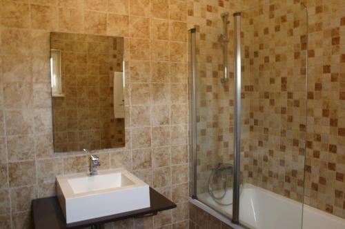 a bathroom with a sink and a shower and a tub at Monte das Faias Cork Farm Hotel in Grândola