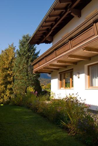 a white house with a wooden roof at Haus Bergheimat in Abtenau
