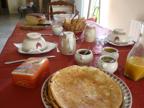 une table avec une assiette de nourriture et une tarte dans l'établissement Relais de la Liberte - Utah Beach, à Sainte-Marie-du-Mont