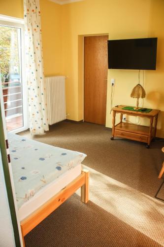 a room with a bed and a table and a window at Landgasthof zur Quelle in Seeshaupt