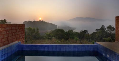 a swimming pool with a view of the mountains at CONTOUR ISLAND RESORT & SPA , wayanad in Tariyod