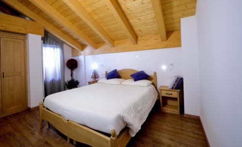 ein Schlafzimmer mit einem Bett und einer Holzdecke in der Unterkunft La Casa al Noce in Mezzana