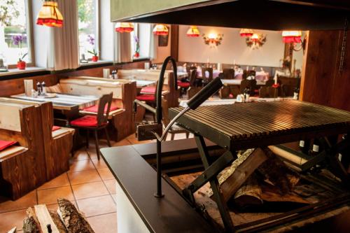 a restaurant with a table and chairs in a room at Landgasthof zur Quelle in Seeshaupt