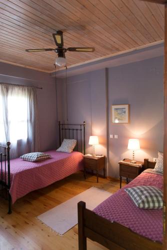 a bedroom with two beds and a ceiling fan at Villa with private garden in Kréstena