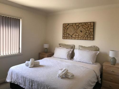 una camera da letto con un letto e due asciugamani di Lake Vista a Jindabyne