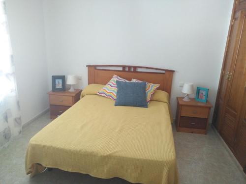 a bedroom with a yellow bed with two night stands at Casa La Charca De Famara in Famara