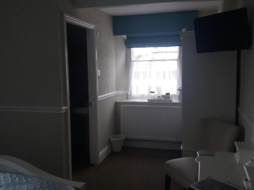 a room with a window and a bed and a radiator at New Hall Bank in Bowness-on-Windermere
