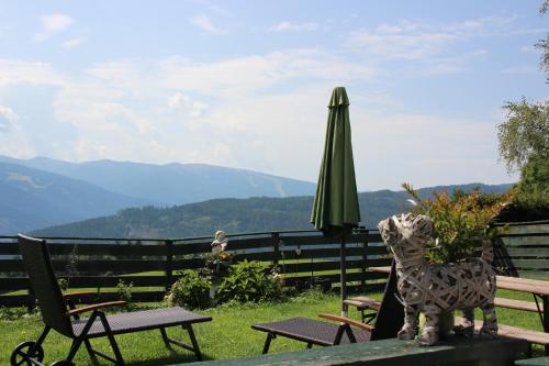 a statue of a dog sitting on a table with an umbrella at Haus Mauken - Appartments mit Panoramablick in Murau