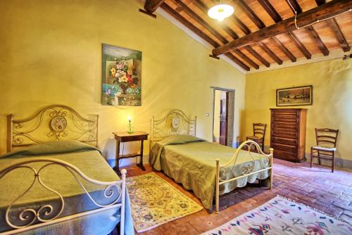 a bedroom with two beds and a table and chairs at Poggiolino by PosarelliVillas in Chitignano