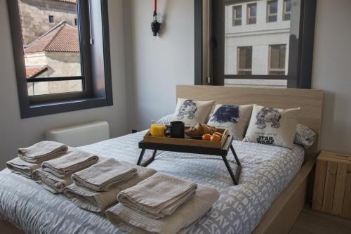 uma cama com toalhas e uma bandeja de fruta em Star Wars Apartment em Salamanca