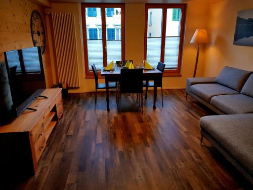 sala de estar con mesa y sofá en Churchstreet appartements, en Meiringen