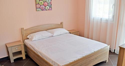 une chambre avec un lit en bois avec des draps blancs dans l'établissement Villa Nina, à Skala Rachoniou