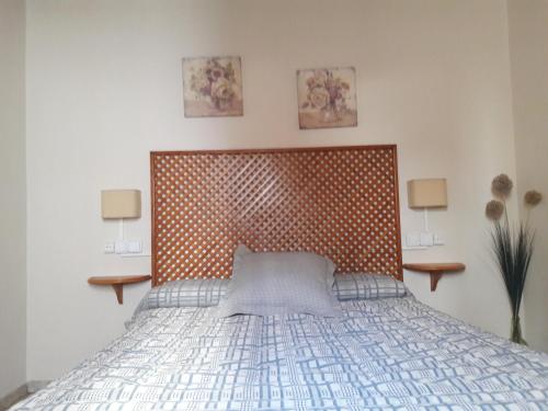 a bedroom with a bed with a wooden head board at Casa Torrubia in Aracena
