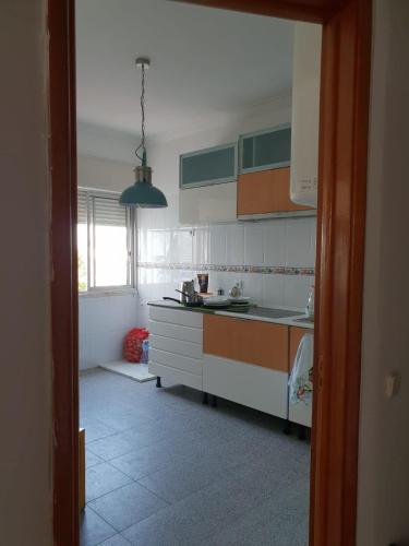 a kitchen with white cabinets and a large window at Yard in Amora