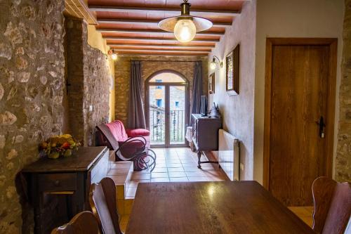 a dining room with a wooden table and chairs at Casa Batlle in Les Iglésies