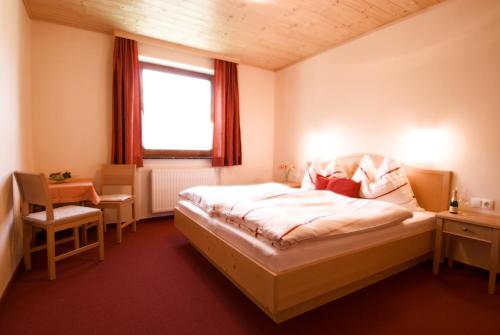 a bedroom with a bed and a desk and a window at Haus Bergheimat in Abtenau