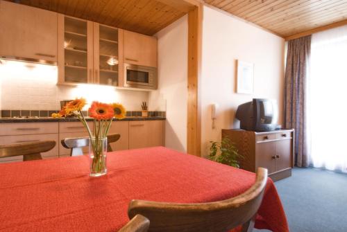 a kitchen with a table with a vase of flowers on it at Haus Bergheimat in Abtenau