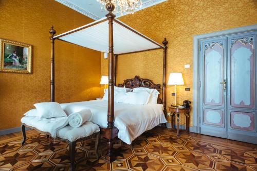 a bedroom with a large bed with a canopy at Relais & Chateaux Villa Crespi in Orta San Giulio