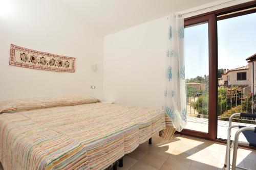 una camera con un letto e una grande finestra di Casa Bianco Navarrese B a Santa Maria Navarrese