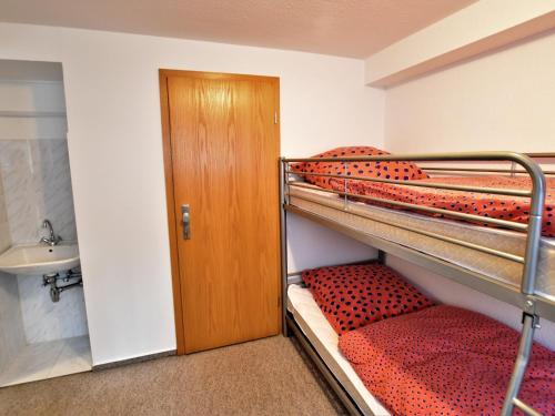 two bunk beds in a room with a door at Luxorious Apartment in Gagelow with Garden in Gägelow