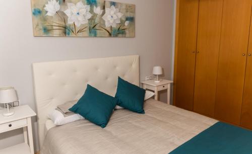 um quarto com uma cama grande e almofadas azuis em Casa AVI em La Cala de Mijas