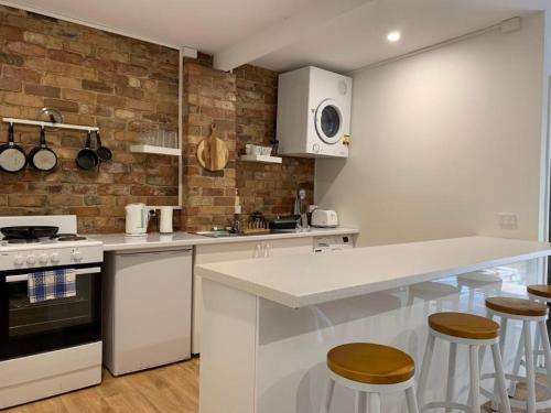 uma cozinha com balcão e bancos em Gorgeous studio 2 minutes from the heart of Subiaco em Perth