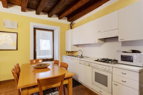 a kitchen with a wooden table and a dining room at Città Antica Charming Flat in Verona