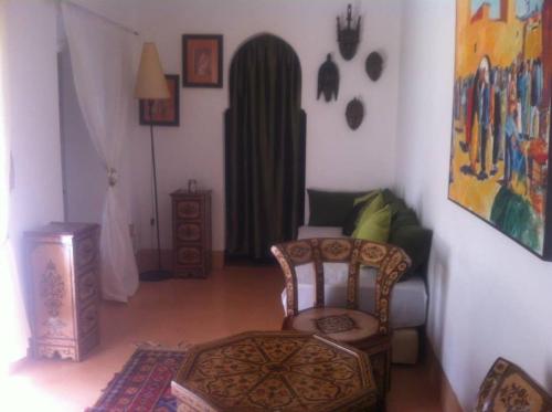 sala de estar con silla y mesa en Dar Nabila, en Marrakech