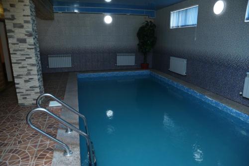 a large swimming pool in a building with a blue pool at Гостиница ШАНЫРАК in Qyzylorda