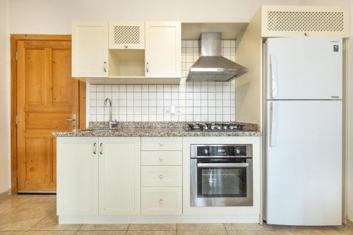 a kitchen with white cabinets and a refrigerator at Old Town Deluxe Flats in Antalya