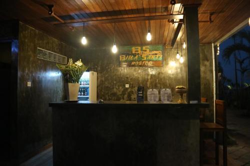 a bar with a vase of flowers on a wall at Bima Sakti Homestay Echo Beach Canggu in Canggu