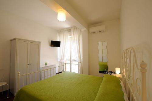 a bedroom with a green bed and a window at Baiadelconero in Numana