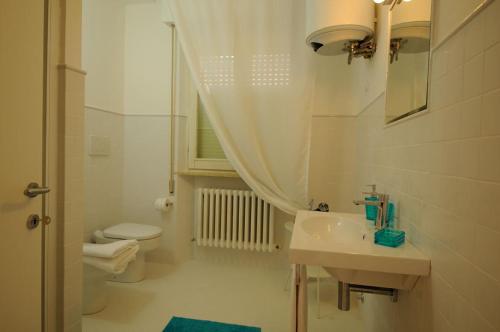 a white bathroom with a sink and a toilet at Baiadelconero in Numana