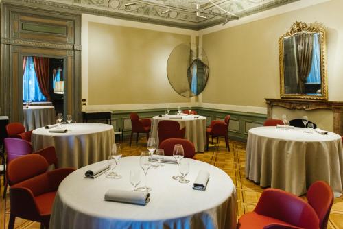 a room with four tables and chairs and a mirror at Relais & Chateaux Villa Crespi in Orta San Giulio