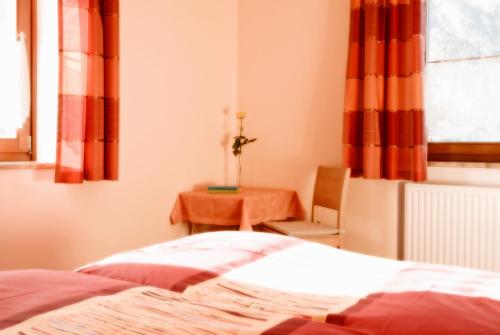 a bedroom with a bed and a table at Haus Bergheimat in Abtenau