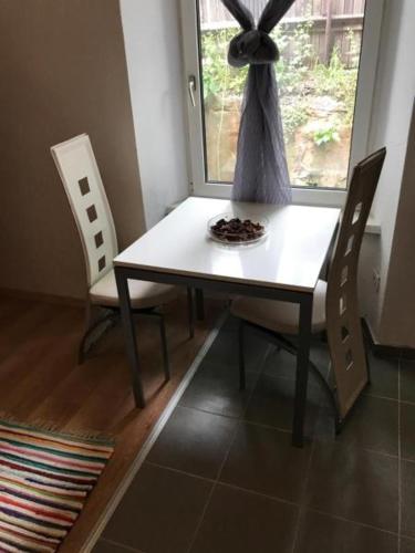 a dining room table with two chairs and a window at Arbeiterwohnungen Graz Hauptbahnhof in Graz