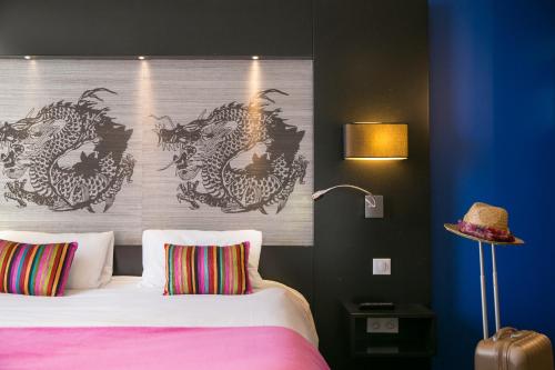 a bedroom with a bed with a large headboard at Le Ceïtya in Saint-Gilles-Croix-de-Vie