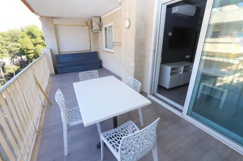 - Balcón con mesa blanca y sillas en DIFFERENTFLATS Grd, en Salou