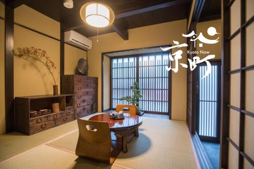 a living room with a table and chairs and a window at Kyomachi Rakunan in Kyoto