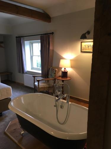 a bathroom with a bath tub in a room at Black Horse in Amberley