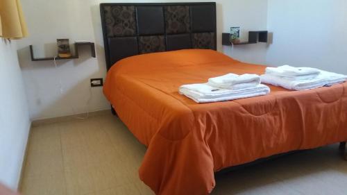 a room with a bed with two towels on it at Posada Entre Dos in Mina Clavero