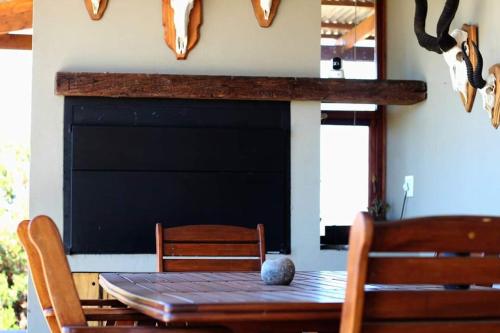 a dining room with a table and chairs and a fireplace at Ribboksfontein Guest Farm in De Rust